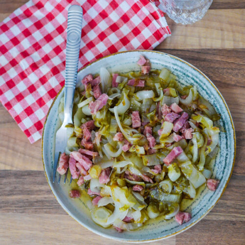 Plat de chou braisé aux lardons sur table en bois.