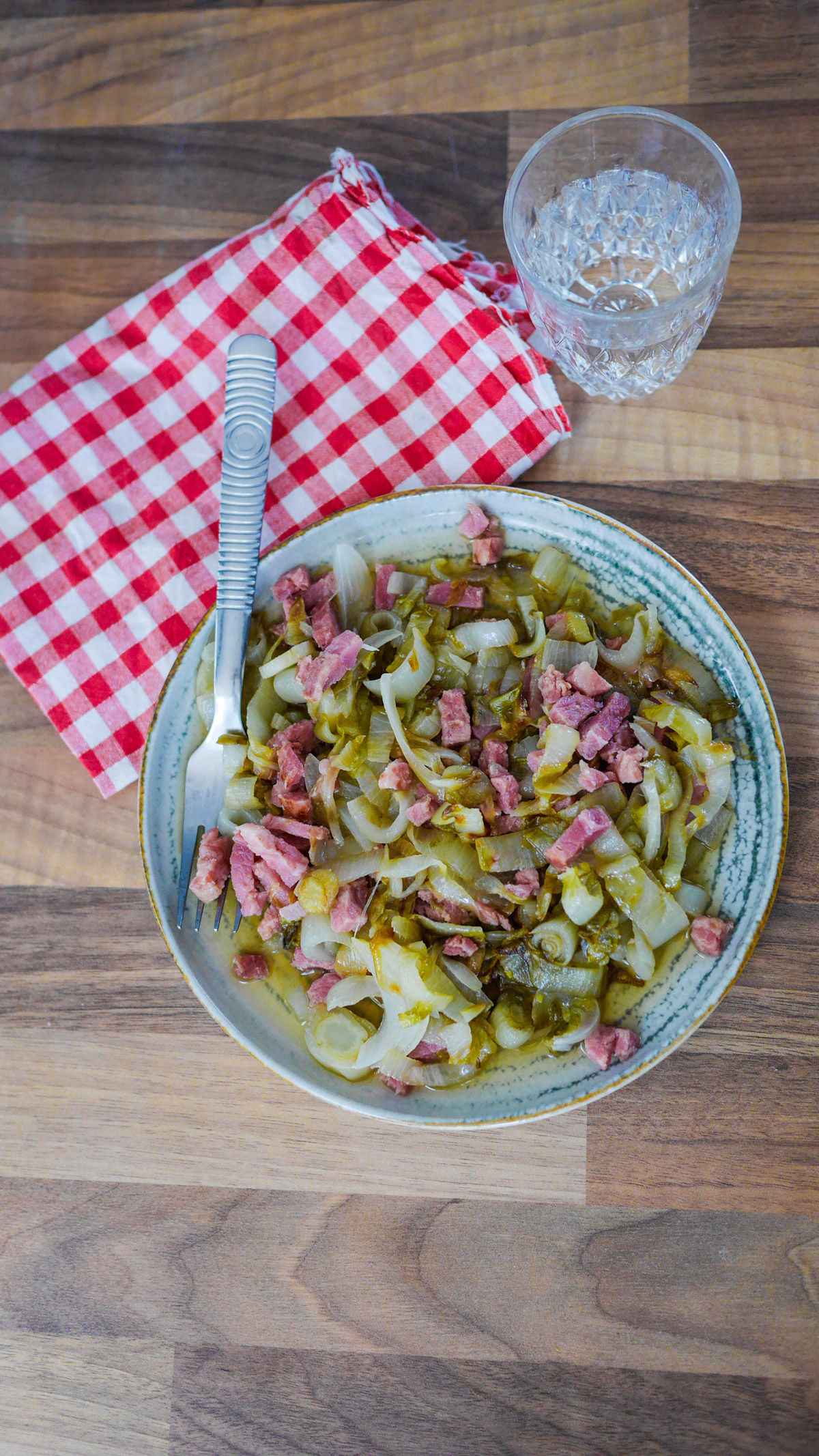 Plat de chou braisé aux lardons sur table en bois.