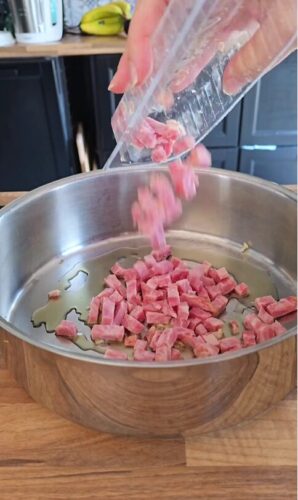 Lardons en dés versés dans une poêle.