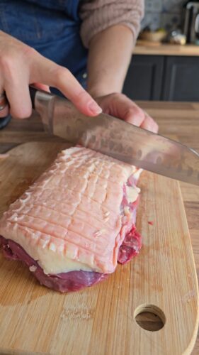 Magret de canard entaillé sur planche à découper.