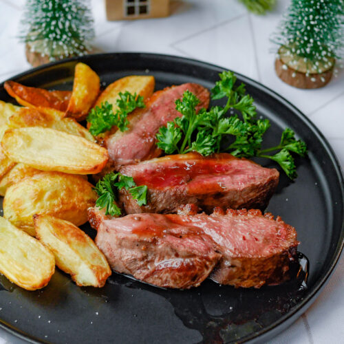 magret de canard tranché, servi avec la sauce miel et vinaigre de framboise et des potatoes