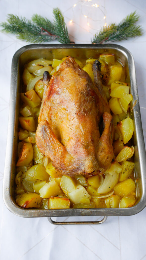 Pintade au four dorée accompagnée de pommes de terre rôties dans un plat de cuisson.