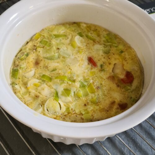 Gratin de poireaux cuit dans un plat blanc.