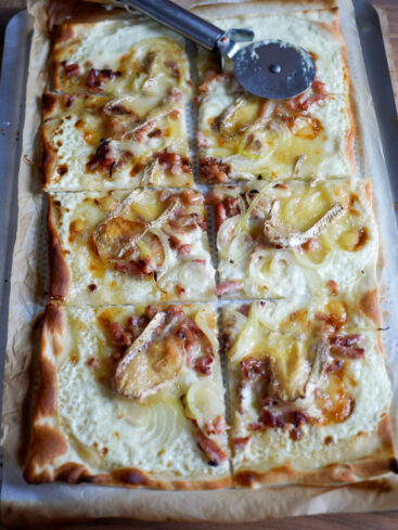 Flammekueche coupée avec trancheuse à pizza, sur plaque
