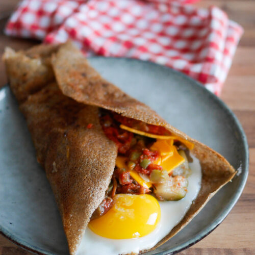 Galette bretonne garnie avec œuf, légumes et fromage.
