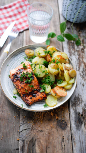 Saumon grillé et pommes de terre sur table rustique