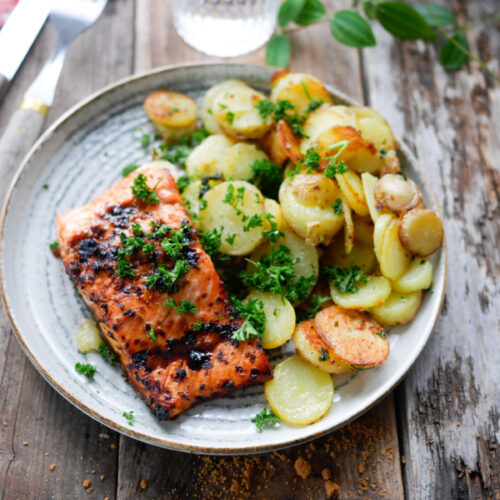 Saumon grillé et pommes de terre sur table rustique