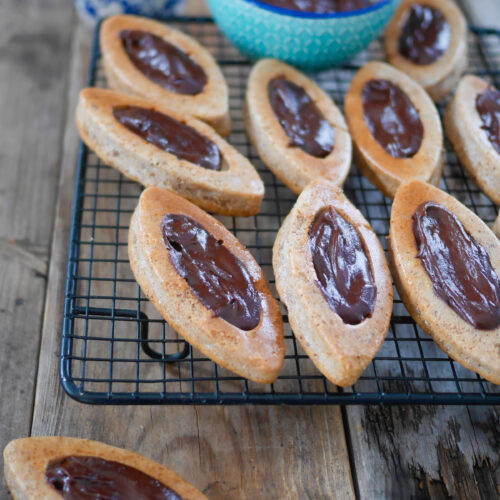 Financiers au chocolat sur grille, table en bois.