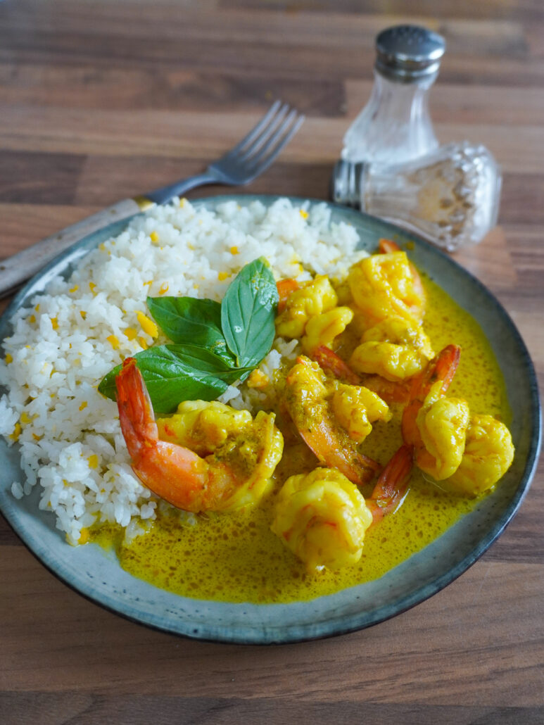 Assiette de crevettes en sauce curry servie avec du riz