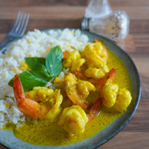 Curry de crevettes crémeux servi avec du riz blanc.