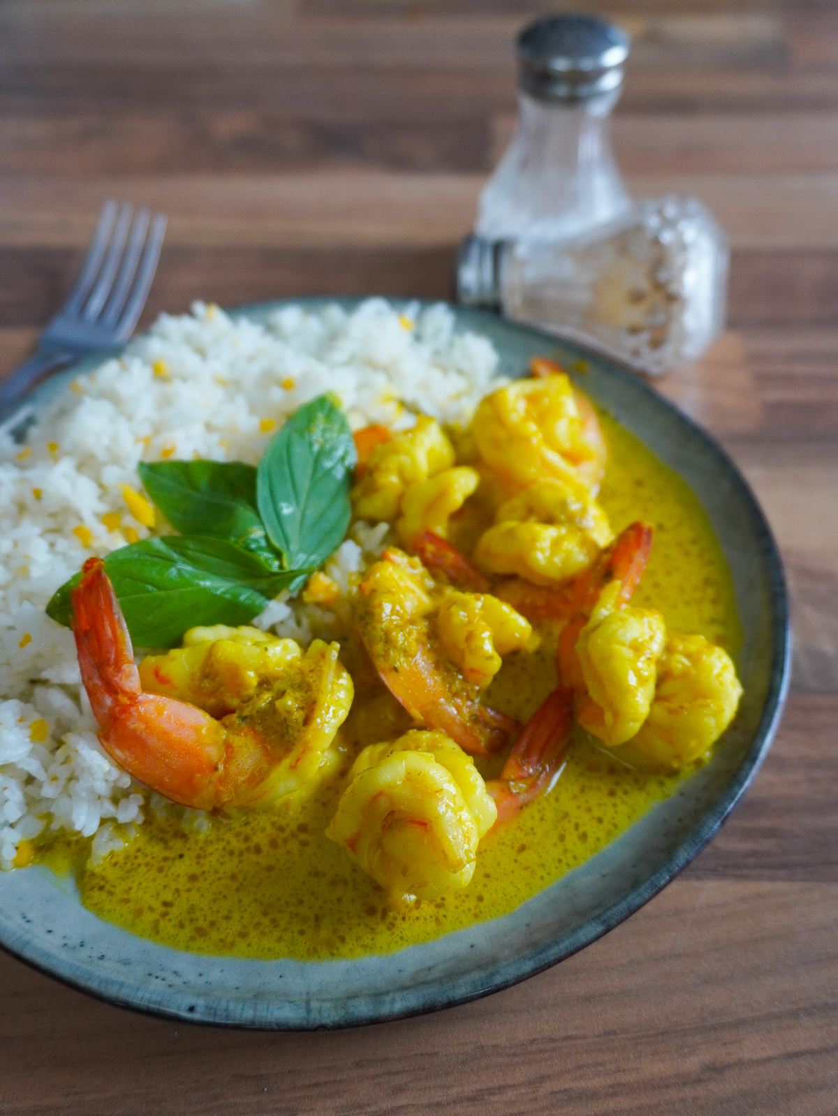 Curry de crevettes crémeux servi avec du riz blanc.