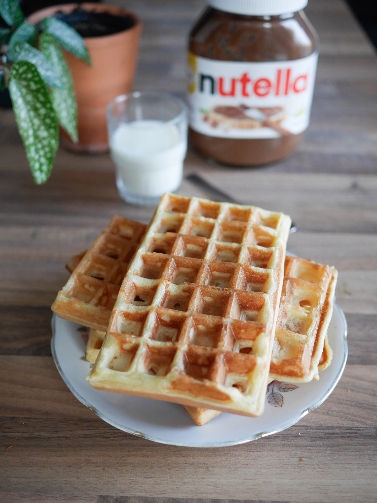 Gaufres, Nutella et lait sur table en bois.