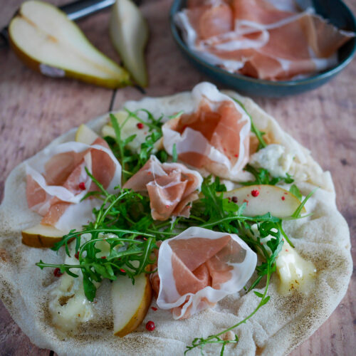 Pizza gourmande avec poire, jambon cru et roquette