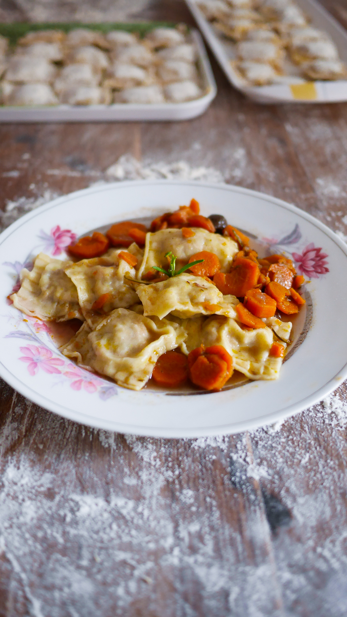 Assiette de raviolis aux carottes sur table farinée
