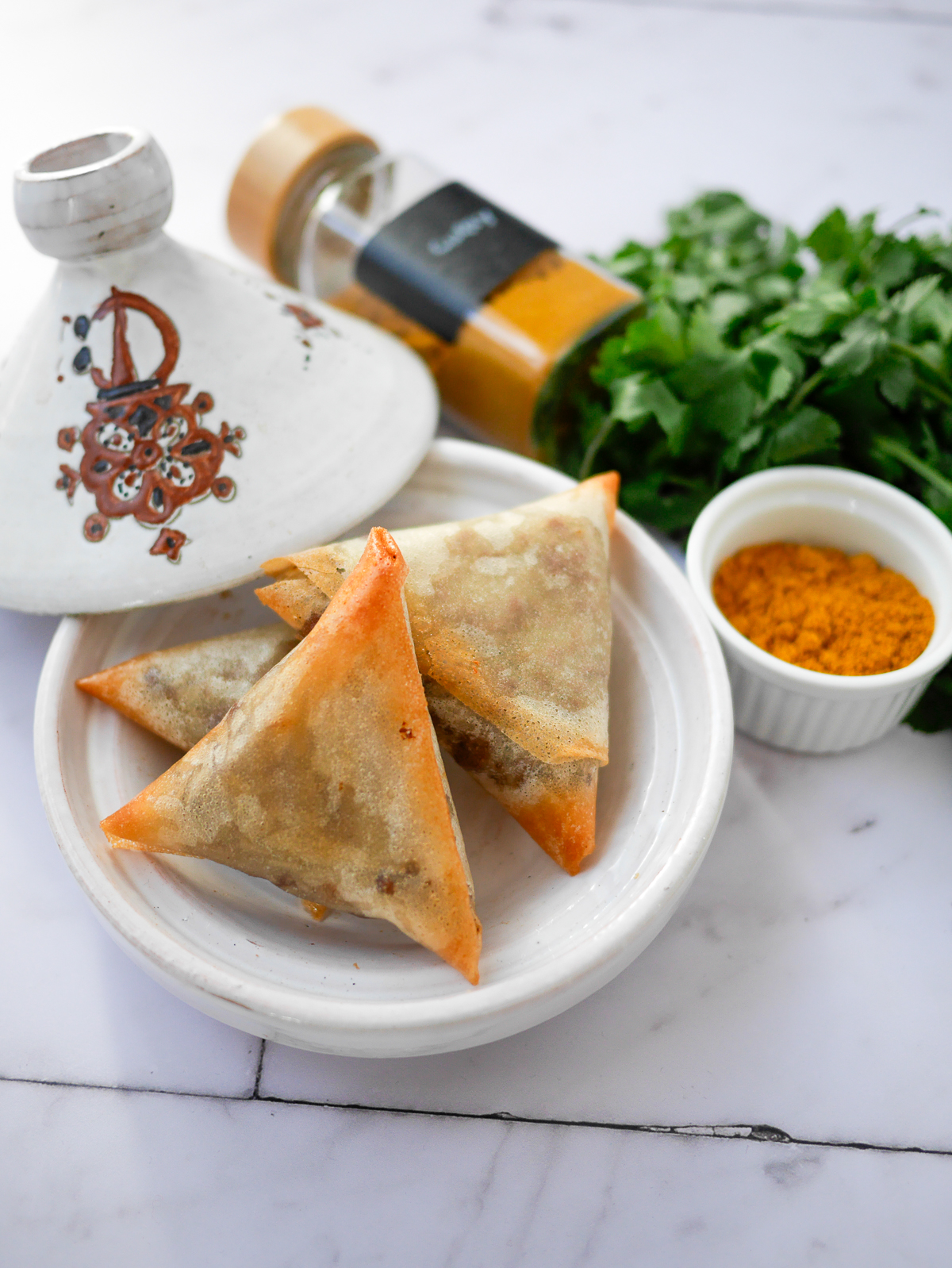 Samoussas, tajine et épices (curry, coriandre).