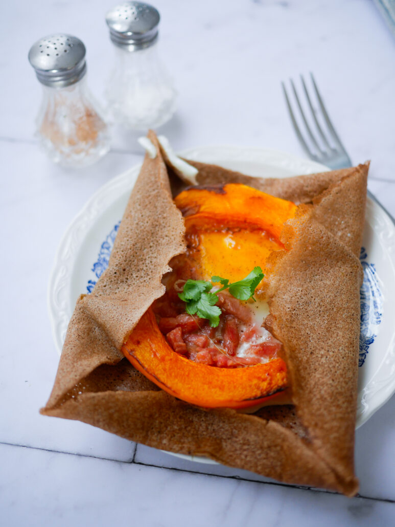 Galette de sarrasin garnie de tranche de courge, d'œuf et de lardons