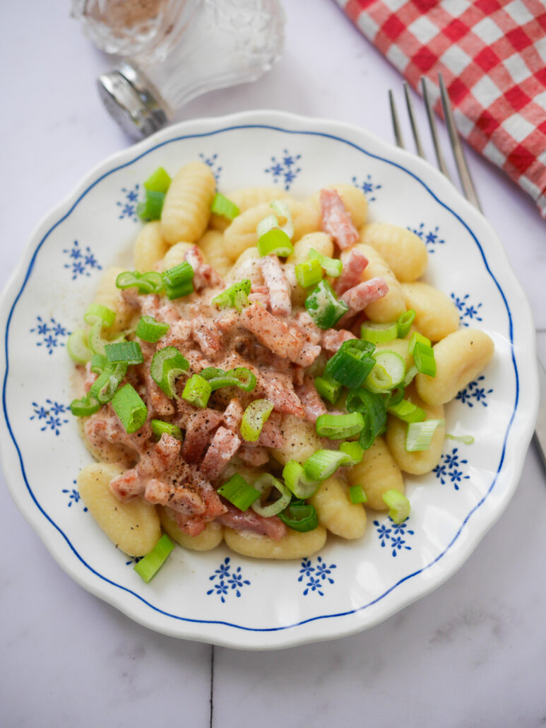 Assiette de gnocchis de pommes de terre aux lardons et oignons nouveau
