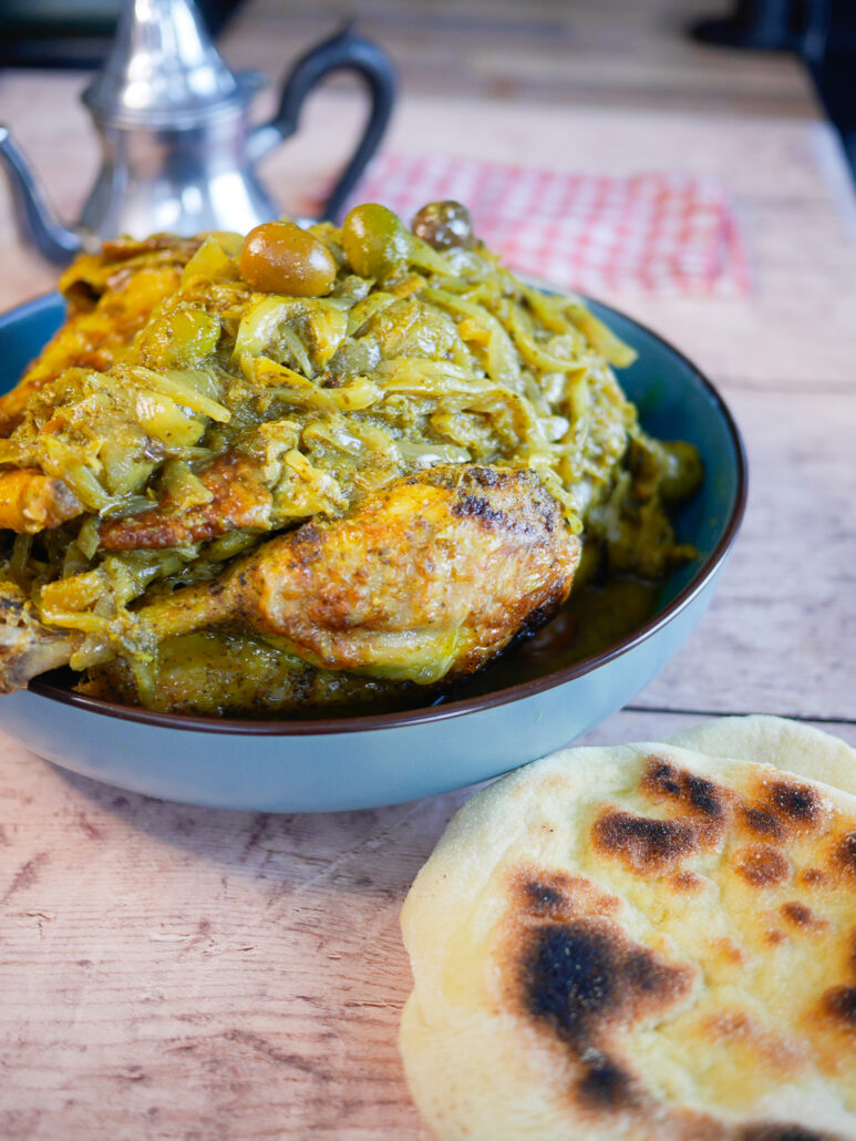 Poulet Mhamer à la marocaine, avec citron confit, olives vertes et oignons fondants, servi avec du pain semoule maison