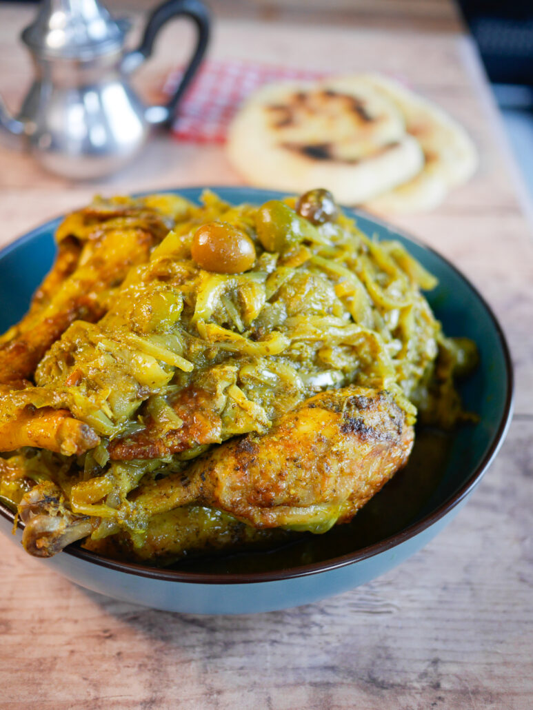 Poulet à la marociane servi avec des oignons fondants, des olives vertes et du citron confit