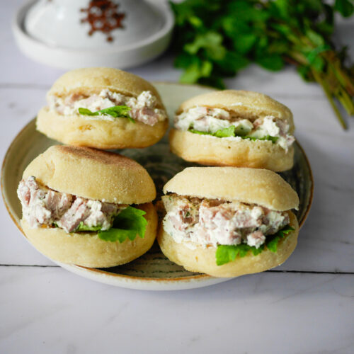 Quatre petits sandwichs au poulet et à la salade.