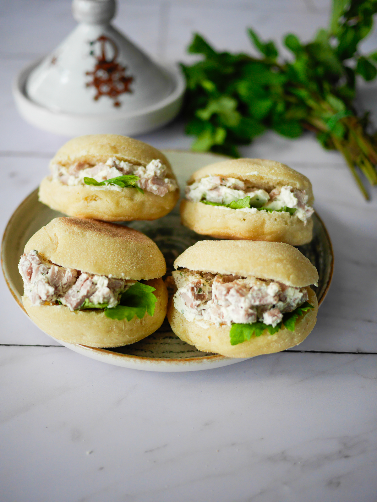 Quatre petits sandwichs au poulet et à la salade.