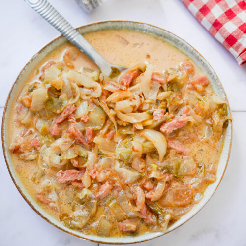 Plat de chou aux lardons crémeux, servi avec une cuillère