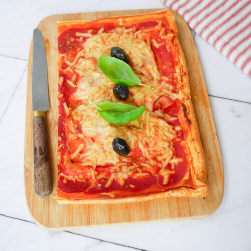 Tarte rectangulaire à la tomate, mozzarella, olives et basilic.