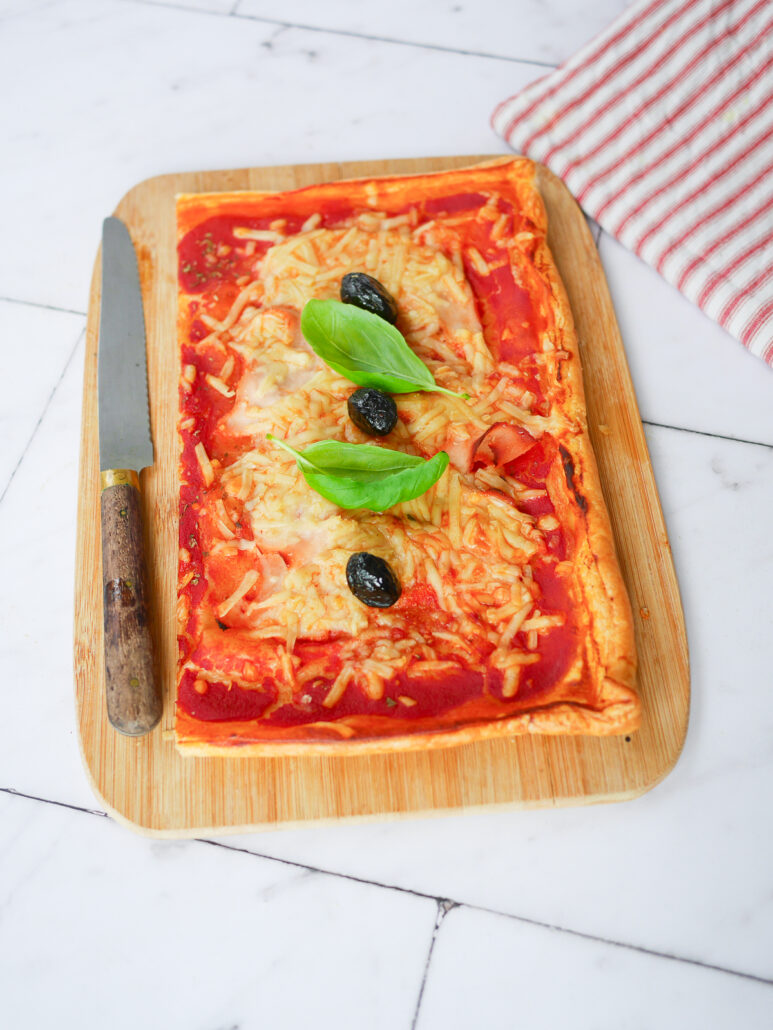 pizza rectangulaire à la pâte feuilletée, jambon fromage olive verte basilic