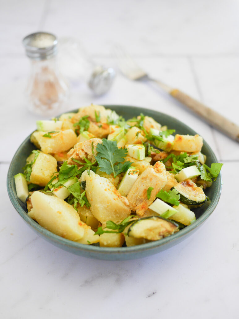 Salade pommes de terre, poulet curry servi dans une coupelle avec du persil parsemé