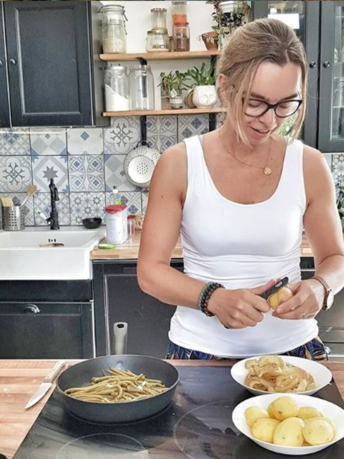 Femme épluche pommes de terre dans une cuisine