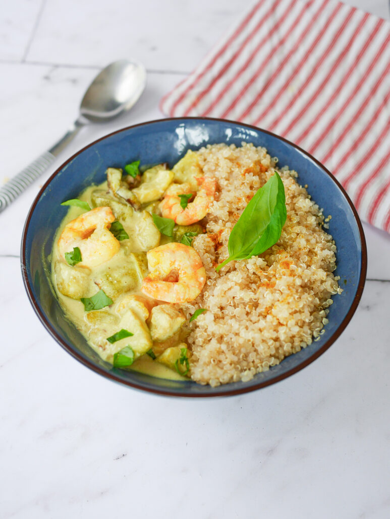 Curry de crevettes aux courgettes, lait de coco et quinoa, servi avec du basilic