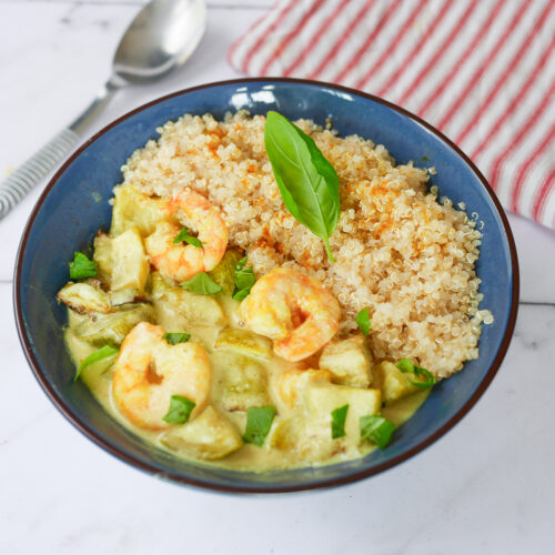 Curry de crevettes et quinoa dans un bol bleu.