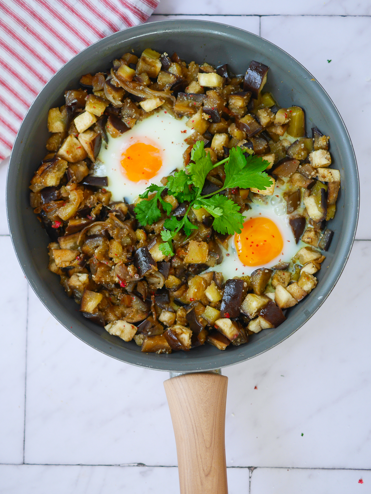Poêlée d'aubergines et œufs au plat, persil frais.