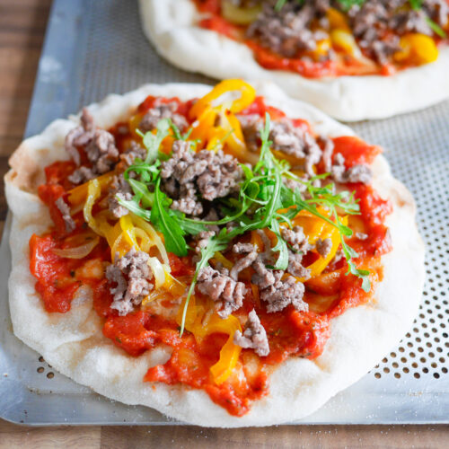 Pizzas individuelles avec viande hachée, poivrons et roquette
