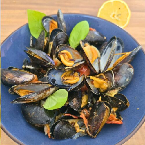 Assiette de moules cuisinées avec citron et basilic
