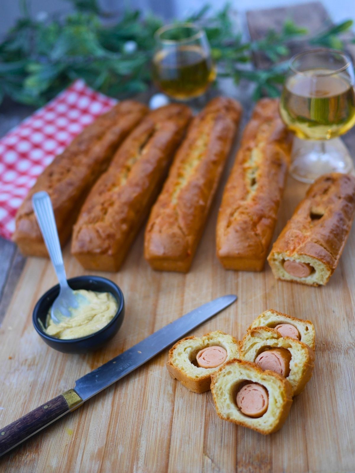 Pains saucisses, moutarde et vin blanc sur planche à découper.