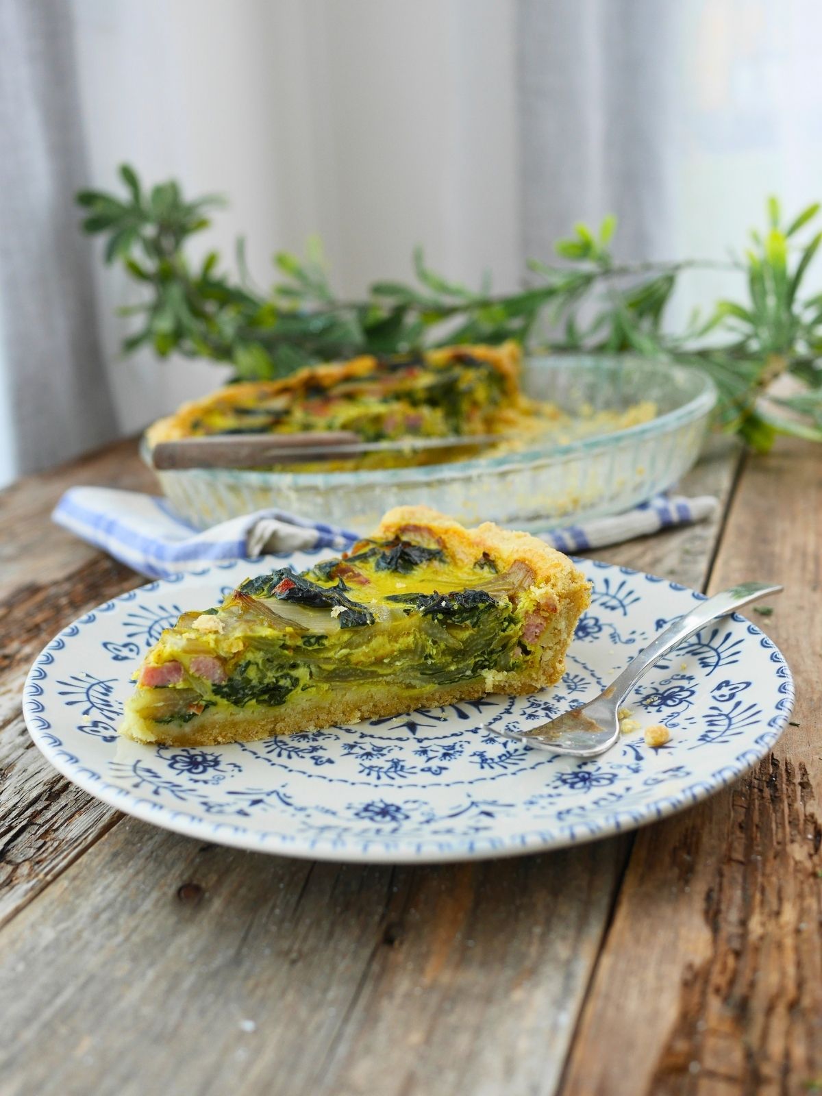 une part de quiche aux blettes et lardons dans une assiette