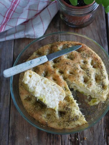 focaccia aux herbes de provence dans un plat rond, découpée