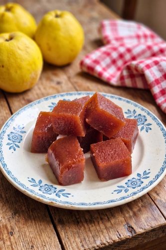 morceaux de pate de coing posés dans une assiette blanche à motifs bleus